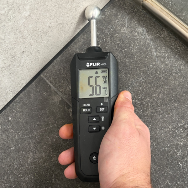 Moisture meter detecting shower leaking behind tiles